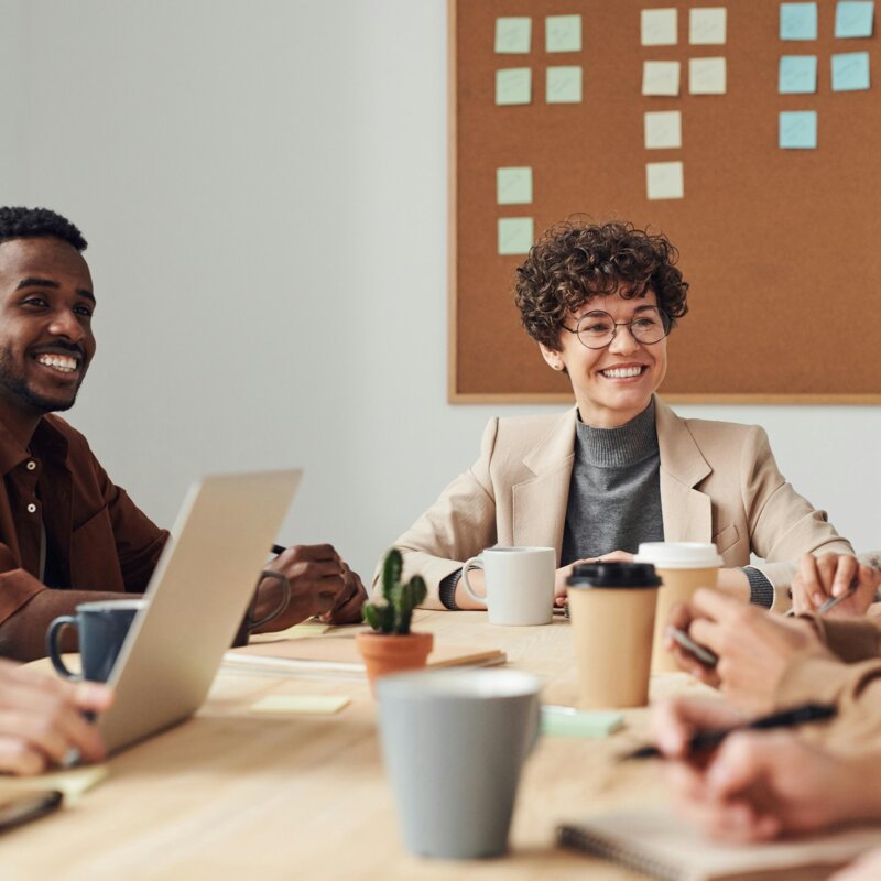 Foto von mehreren Personen in einem Meeting, auf dem Tisch stehen Arbeitsmaterialien und Kaffees  | © Pexels | Fauxels