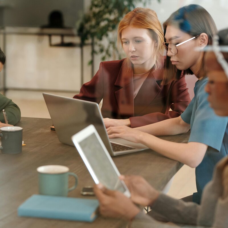 Foto von Personen in einer Besprechung, auf dem Tisch stehen Kaffeetassen. | © Pexels | Diva Plavalugna