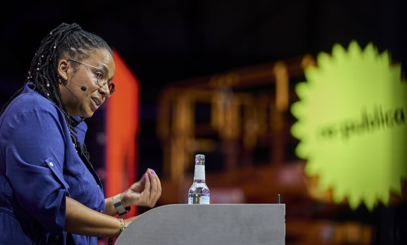 Tupoka Ogette bei einer Veranstaltung am Redner*innenpult.  | © Mike Schmidt | IMAGO: Tupoka Ogette macht wichtige Antirassismus-Arbeit. 