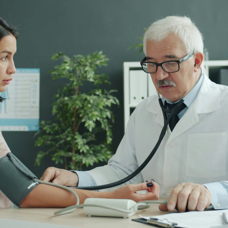 Ein männlicher Arzt misst den Puls einer weiblichen Patietin. | © Vitaly Gariev | Unsplash