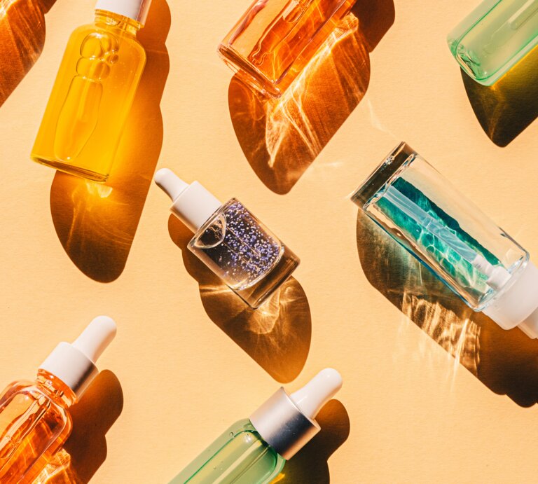 Flaschen mit Gesichtsseren auf gelbem Hintergrund | © Getty Images|Olena Malik
