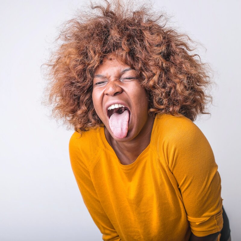 eine Frau in einem gelben Pullover sieht geekelt aus | © Pexels | Andrea Piacquadio