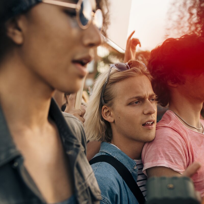 Gruppen von Menschen, die eng zusammensteht und Rufe von sich gibt. | © Foto: Youssef Naddam | Getty Images 