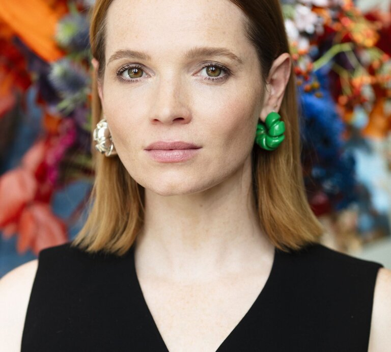 Karoline Herfurth in schwarzer Weste vor einem großen Blumenstrauß | © Karoline Herfurth