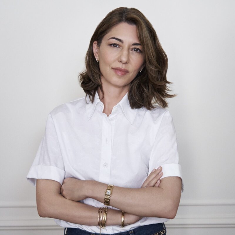 Das Bild zeigt die Regisseurin Sofia Coppola vor einer weißen Wand stehend. | © Sofia Coppola hat Priscilla Presleys Geschichte verfilmt. Foto: Melodie McDaniel