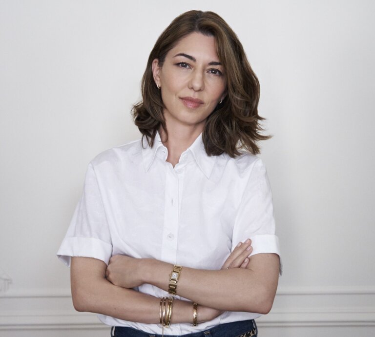 Das Bild zeigt die Regisseurin Sofia Coppola vor einer weißen Wand stehend. | © Sofia Coppola hat Priscilla Presleys Geschichte verfilmt. Foto: Melodie McDaniel