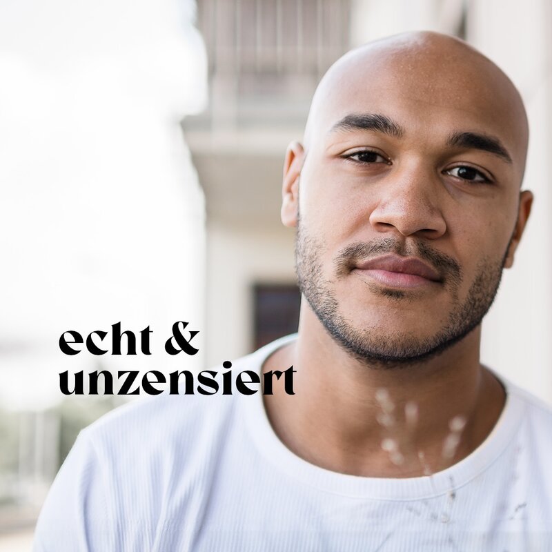 Schauspieler Malick Bauer steht auf einem Balkon und trägt ein weißes T-Shirt. | © Lucas Lentes