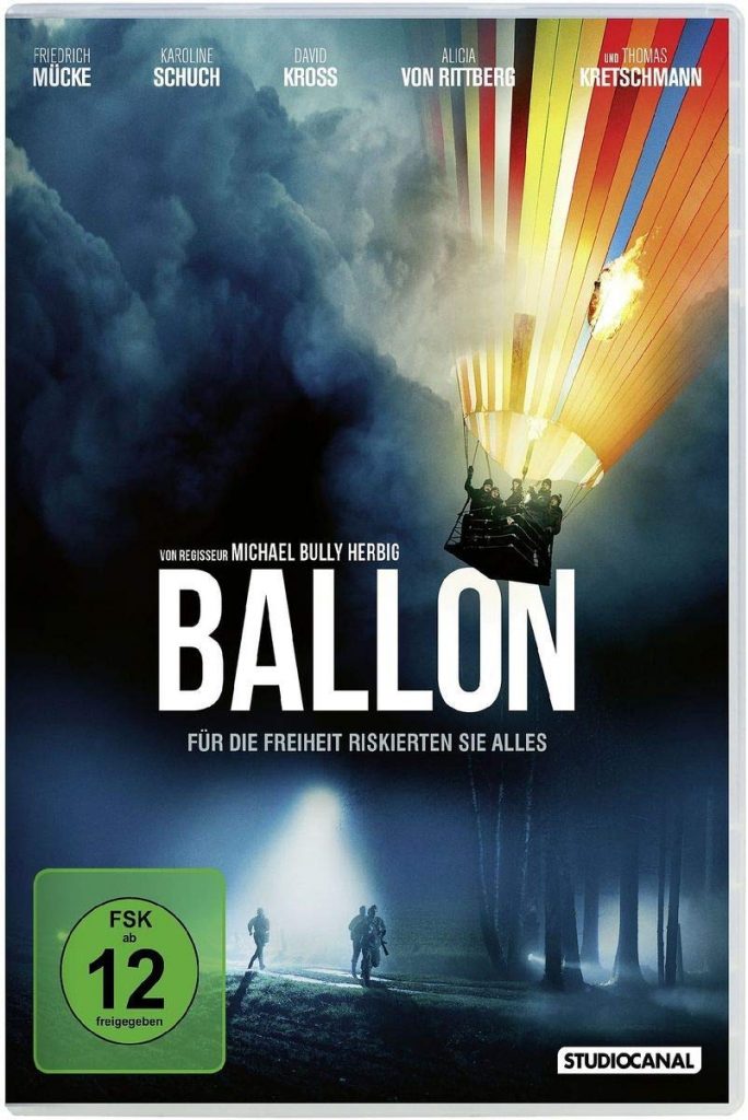 Ein bunter Heißluftballon steigt in den Himmel auf. Unter ihm suchen Menschen mit Taschenlampen die Dunkleheit ab.