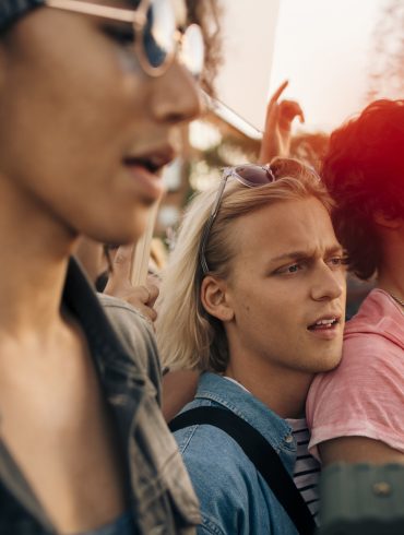 Gruppen von Menschen, die eng zusammensteht und Rufe von sich gibt.