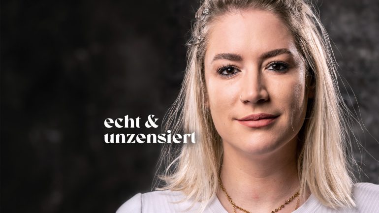 Krankenschwester Franziska Böhler steht vor einer dunklen Fotowand und lächelt.