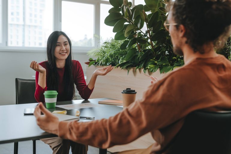 Happy businesswoman having discussion with businessman at desk in office model released, Symbolfoto property released, YTF03299