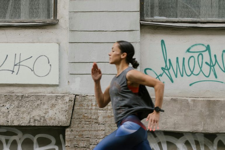 Frau joggt in hohem Tempo durch die Stadt.