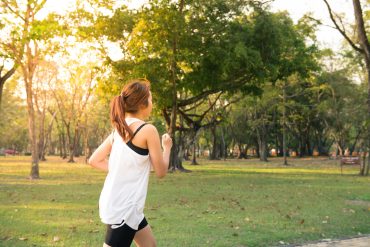 Frau joggt durch den Park.