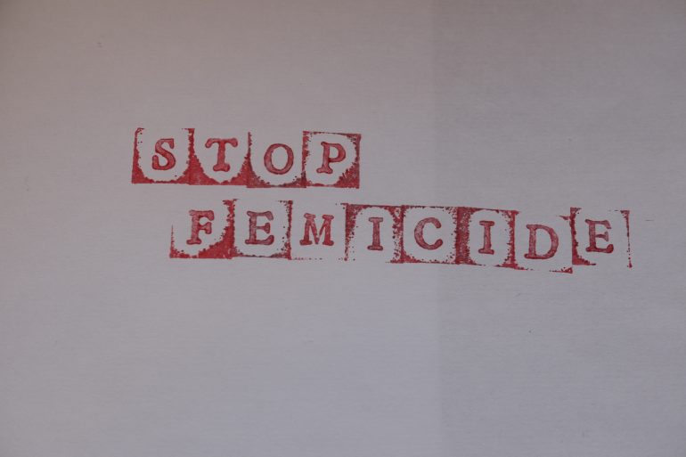 Das Foto zeigt in gestempelten Buchstaben die Worte: Stop Femicide