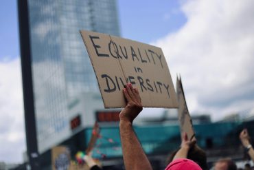 Equality in Diversity steht auf dem Schild, das ein*e Demonstrationsteilnehmer*in in die Luft hält.