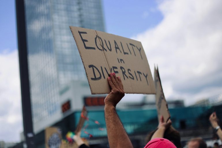 Equality in Diversity steht auf dem Schild, das ein*e Demonstrationsteilnehmer*in in die Luft hält.
