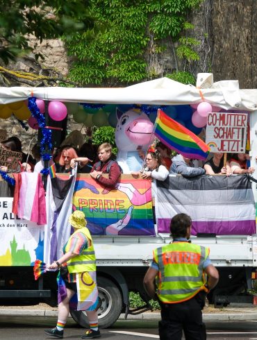 Wagen mit Pride-Besucher*innen fährt durch Wernigerode. Es ist bunt, aber weniger bunt als in den letzten Jahren, weil die Bedrohungslage größer ist.